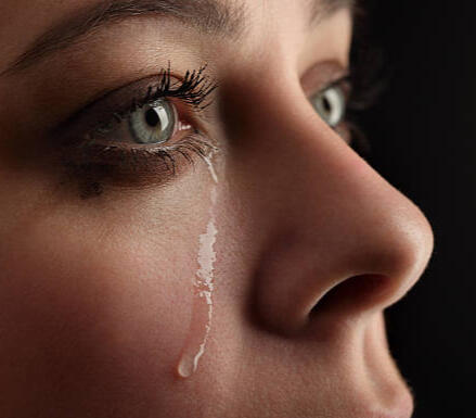 Close-up side profile of a young woman with a tear rolling down her face, illustrating the financial and emotional impact of lacking final expense coverage in Georgia.